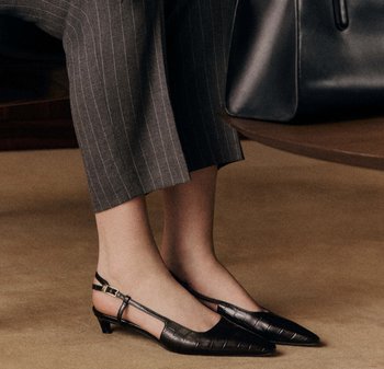 Des ballerines noires en cuir avec un talon bas, un bout pointu, un motif texturé et une sangle ajustable à la cheville.