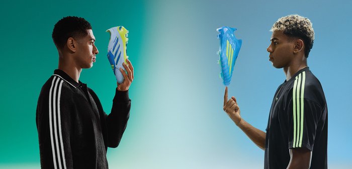 Deux hommes se font face en tenant des crampons de football Adidas, l'un jaune néon et blanc, l'autre bleu translucide, sur un fond dégradé vert sarcelle.