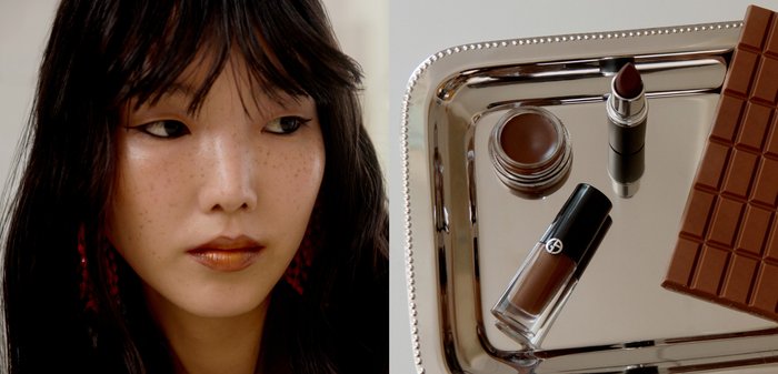 Vrouw met donker haar en bronzen lippen kijkt naar een zilveren dienblad met bruine make-upproducten en een chocoladereep.