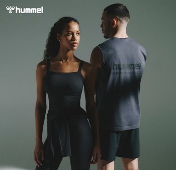 Zwarte sportieve tanktop met verstelbare banden en geribbelde textuur; gecombineerd met high-waisted legging. Mannelijke model in een donker mouwloze shirt erachter.