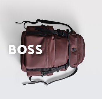 Mochila color marrón con múltiples compartimentos, material de nylon suave, correas ajustables y un acento de logo. Presenta cremalleras y hebillas resistentes.