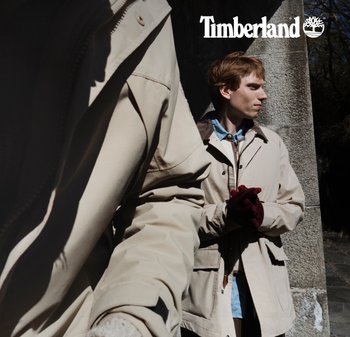 Beige Oberbekleidung mit strukturiertem Design, kombiniert mit einem blauen Hemd. Bemerkenswerte Details: strukturiertem Stoff, Reißverschlüsse und einem dunklen Akzentkragen.