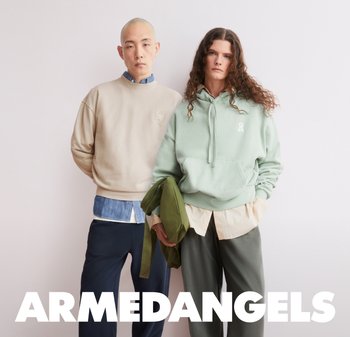 Due modelli posano contro uno sfondo neutro indossando outfit casual a strati; uno con felpa beige e camicia blu, l'altro con felpa con cappuccio menta e giacca verde.