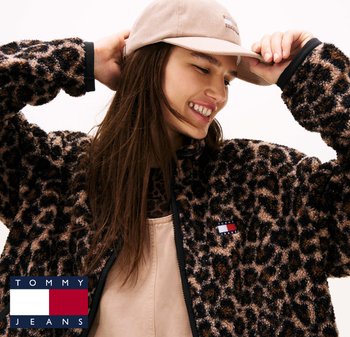 Leopard print fleece jacket with a black trim, featuring a discreet logo and a tan cap. The fabric has a soft texture and loose fit.