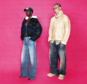 Due modelle sono in piedi davanti a uno sfondo rosa. Una indossa una giacca nera foderata in pelliccia e jeans a gamba larga. L'altra indossa un maglione di maglia beige e jeans larghi.