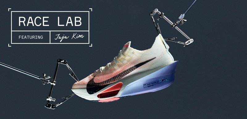 Chaussure de course Nike avec semelle Air Zoom visible suspendue par des pinces mécaniques sur un fond sombre, avec le texte "Race Lab featuring Juju Kim".