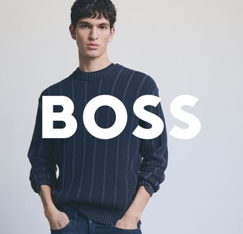 Pull en maille côtelée bleu marine avec un col rond et des poignets roulés. Motif texturé notable et coupe décontractée. Le modèle se tient devant un fond uni.
