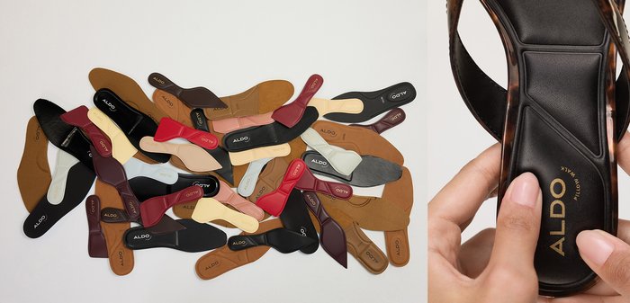 Zwei Hände halten eine schwarze flache ALDO-Sandale mit Schildpatt-Rahmen, die die gepolsterte Innensohle mit der Aufschrift "Pillow Walk" zeigt.