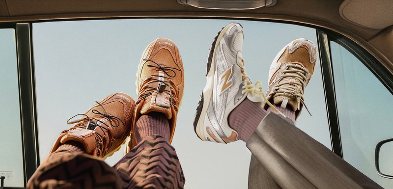 Deux paires de baskets : l'une en maille orange-brun avec des accents noirs, l'autre en blanc et argent avec une semelle crème, toutes deux dotées de lacets.