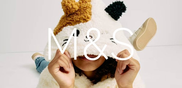 Sweat à capuche en peluche blanc avec un design de chat et une capuche à motif marron et noir. Les manches sont larges avec des poignets côtelés.