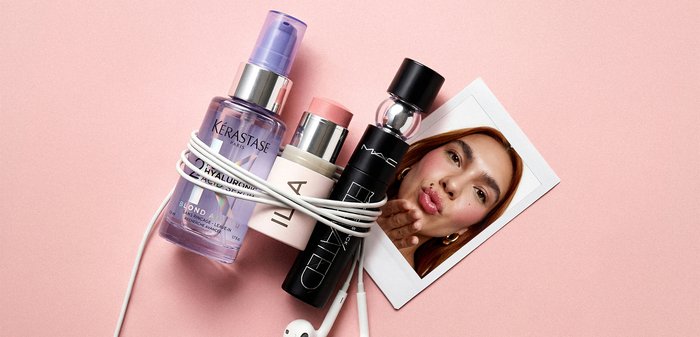 Trois flacons de cosmétiques avec un câble d’écouteur blanc enroulé autour d’eux à côté d’une photo d’une femme envoyant un baiser sur un fond rose.