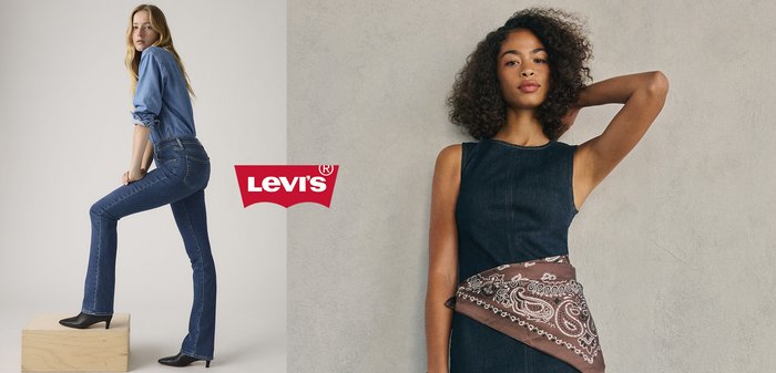 Woman wearing blue denim jeans and shirt, black heeled boots, posing with one foot on wooden block, Levi's logo in corner.