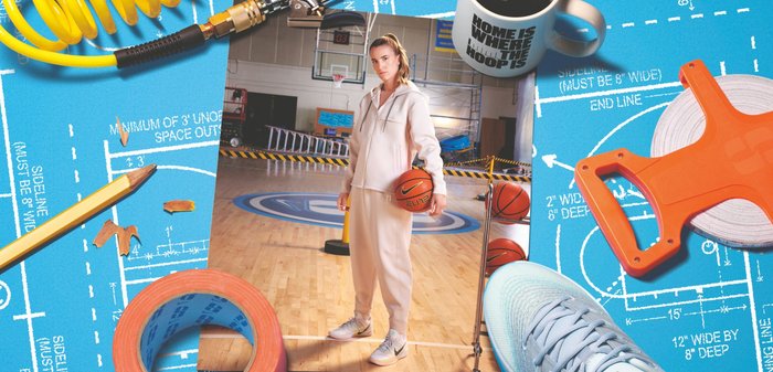 Survêtement blanc avec veste zippée et pantalon assorti. Chaussures de basket bleu clair. Ballon de basket à la main. Fond plan architectural avec outils de construction.