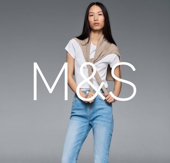 Light grey background; model wearing a white t-shirt, with blue jeans and a beige cardigan draped around shoulders. Prominent M&S logo.
