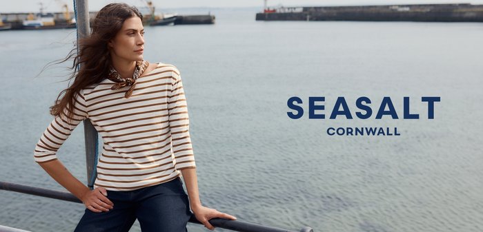 Pruhovaná blůza s třičtvrtě rukávy v krémové a hnědé barvě s kulatým výstřihem. Nosit s tmavě modrými džíny; kolem krku je uvázaná hnědá šála.