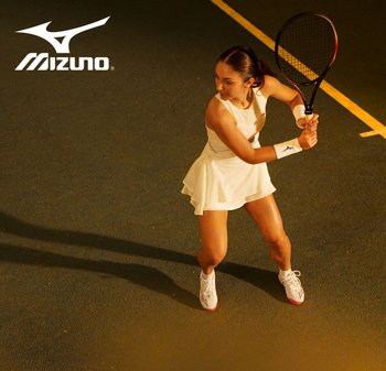 Vestido deportivo blanco con textura de malla y falda acampanada, combinado con zapatillas de tenis blancas y rojas. Jugadora en acción en la cancha.