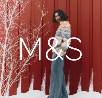 Wielobarwny, puszysty sweter dzianinowy z poziomymi paskami w odcieniach brzoskwini, kremu i szarości; zestawiony z jasnoszarymi, szerokimi spodniami.