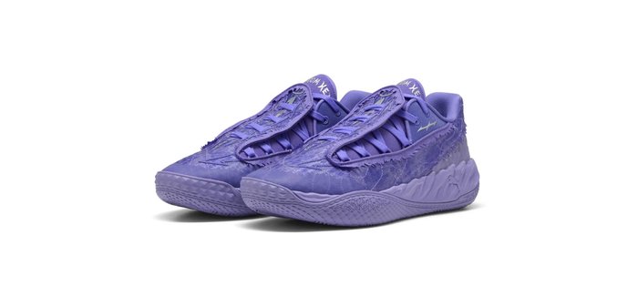 Paire de chaussures de sport violettes avec motifs ondulés texturés et design à lacets, présentée sur fond blanc.