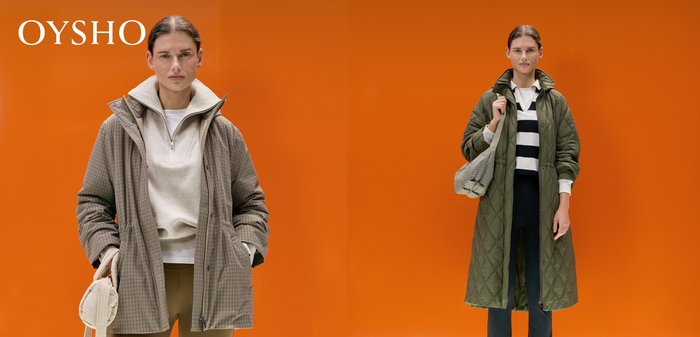 Frau trägt eine beige karierte Jacke, einen cremefarbenen Pullover mit Viertelreißverschluss und braune Leggings, hält eine hellbeige gesteppte Tasche vor einem orangefarbenen Hintergrund.