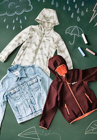 Três casacos expostos: um impermeável verde-claro com capuz e padrão de nuvens, uma jaqueta de ganga azul e um hoodie vermelho-escuro com fecho éclair e detalhes laranja.