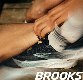 Brooks Ghost hardloopschoen in donkerblauw met gele accenten. Beschikt over een ademende mesh bovenkant, een gevoerde zool en een veilig vetersysteem.