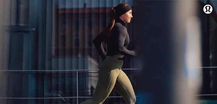 Sportkleding met een strak zittende, zwarte longsleeve top en slim-fit, olijfgroene leggings met een ritszak.