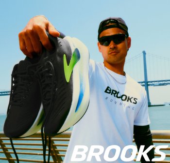 Zwarte hardloopschoenen met groene en blauwe accenten, voorzien van een textuurmateriaal, vetersluiting en een lichtgewicht constructie.