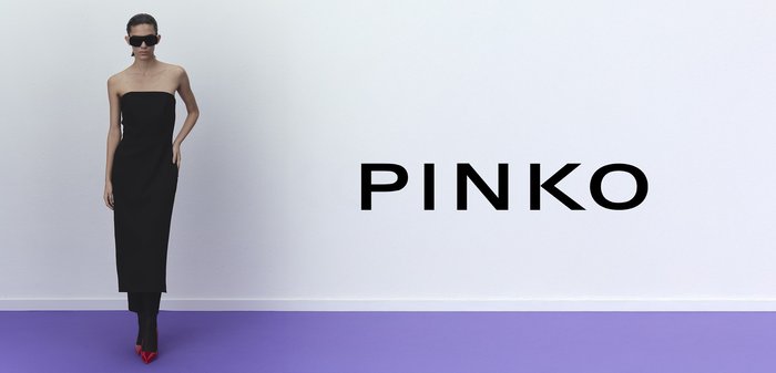 Vestido negro sin mangas de largo hasta el suelo con una silueta ajustada, combinado con tacones de aguja rojos brillantes y gafas de sol negras de gran tamaño.