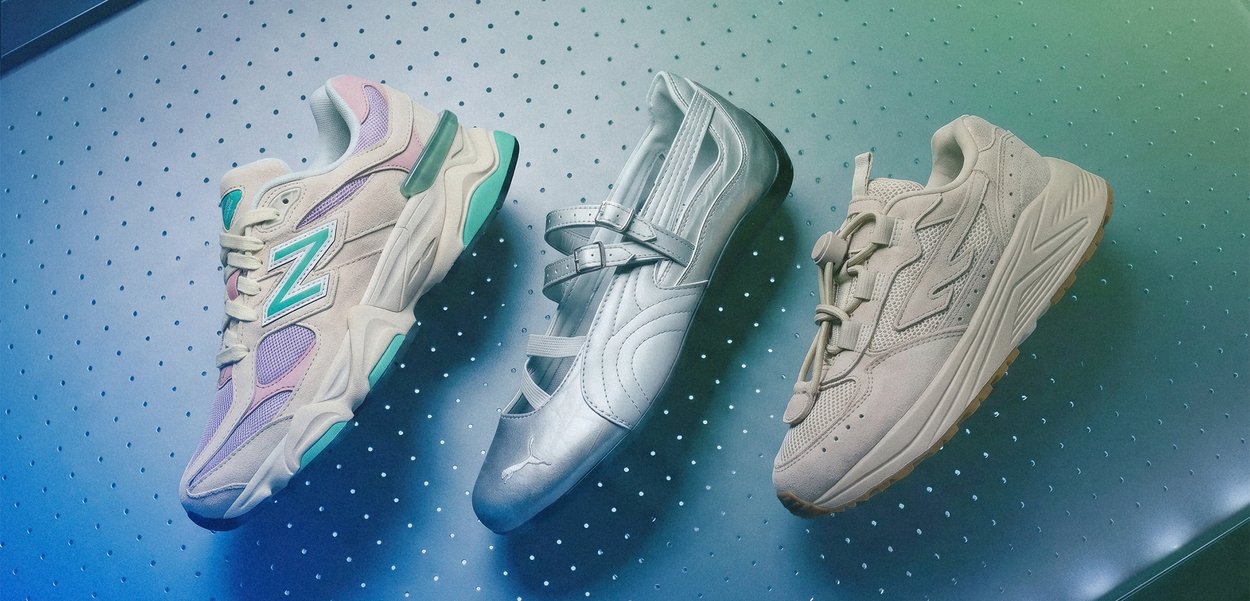 Drei einzelne Schuhe auf einer perforierten Oberfläche: ein pastellfarbener New Balance Sneaker, ein silberner Mary Jane und ein beiger Sneaker.