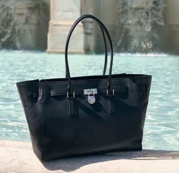 Borsa a tracolla in pelle nera con due manici lunghi, hardware argentato, chiusa con un lucchetto e una chiave, con superficie testurizzata e forma rettangolare.
