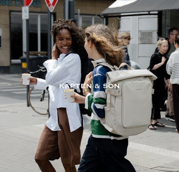 Béžový batoh se strukturovaným designem, hladkým povrchem a nastavitelnými popruhy. Obsahuje přední kapsu a minimalistické logo.