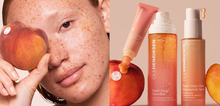 Ole Henriksen skincare products including Peach Glaze Glow Mist, Peach Glaze Glow Niacinamide Serum, lip treatment tube, and fresh peach fruit.