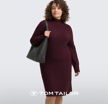 Bordowa sukienka dzianinowa z wysokim kołnierzem i długimi rękawami, o dopasowanym kroju i pionowych szwach. Modelka trzyma czarną torebkę.