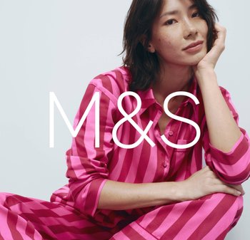 Pink striped loungewear set with a button-up shirt and matching pants made from a smooth fabric; model resting chin on hand.