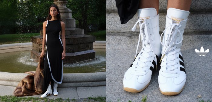 White high-top sneakers with black stripes and gold accents, paired with a sleek black dress featuring white side detailing. Brown fur draped nearby.