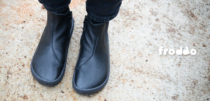 Čierne kožené členkové čižmy s textúrovaným povrchom, so bočnými zipsami a zaoblenou špičkou, umiestnené na flexibilnej čiernej podrážke.