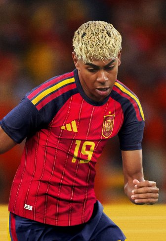 Κόκκινη και μπλε ποδοσφαιρική φανέλα με χρυσές λεπτομέρειες, με οριζόντιες ρίγες και αριθμό παίκτη 19. Υφή υφάσματος και αθλητική εφαρμογή.