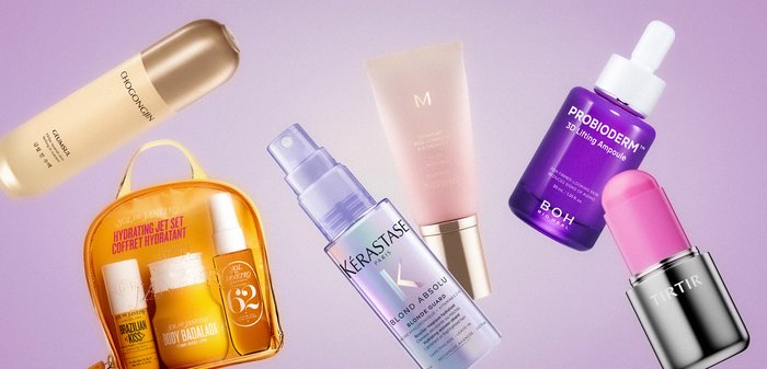 Six flacons et tubes colorés de soins de la peau et de produits de beauté disposés sur un fond violet clair, incluant des sérums, des crèmes et une trousse de voyage.