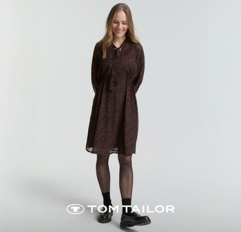 Brązowa sukienka w panterkę z długim rękawem, zapinana na guziki, z elastycznym taliowaniem. Przezroczysta tkanina, w połączeniu z czarnymi butami i skarpetkami.