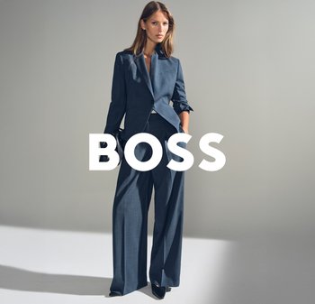 Blazer su misura blu scuro con colletto alto, abbinato a pantaloni a gamba larga. Tessuto liscio, design minimalista e marchio ben visibile.