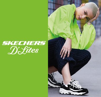 Black and white Skechers D'Lites sneakers with a chunky sole, paired with a neon green zip-up jacket and striped navy pants.