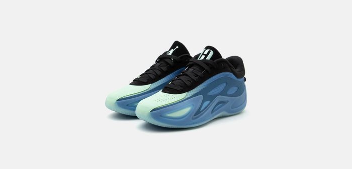 Paire de baskets basses modernes en bleu et vert menthe avec des lacets et semelles noirs, présentées en angle sur fond blanc.