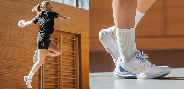 Vrouwelijke atlete in de lucht tijdens het gooien van een handbal binnenshuis, gekleed in zwarte sportkleding en witte sportschoenen met gouden accenten.