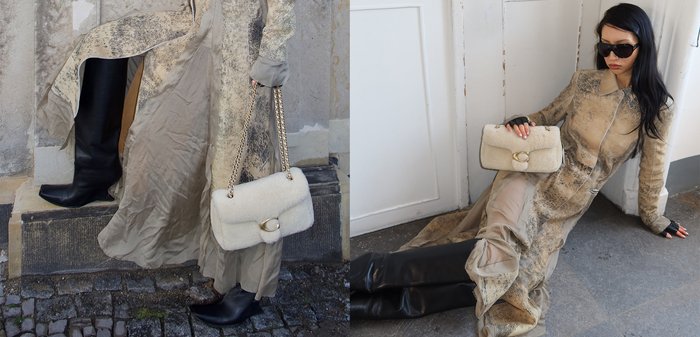 Frau trägt einen beigen, gemusterten langen Mantel, schwarze Stiefel, Sonnenbrille und hält eine cremefarbene Pelztasche mit goldenen Kettenriemen.