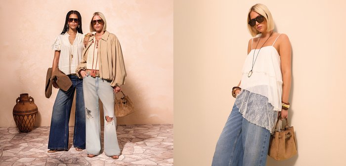 Twee vrouwen dragen een zonnebril en casual outfits in neutrale tinten. Ze staan tegen een beige muur, waarbij de ene een suède jas vasthoudt en de andere een suède tas.