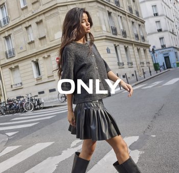 Donkergrijze gebreide trui met korte mouwen en gouden knopen, gecombineerd met een zwarte geplooide neplederen rok en zwarte laarzen tot de knie.