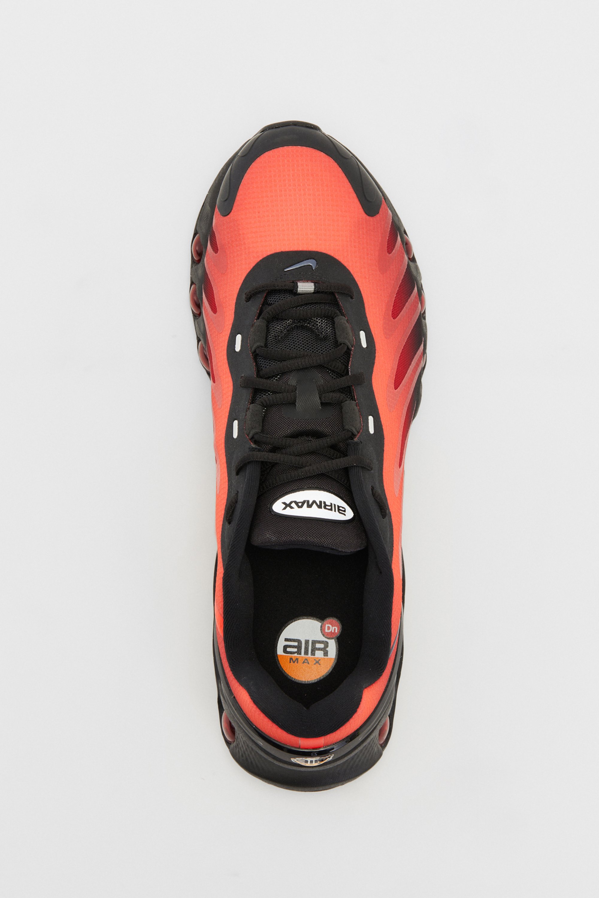 Red and black Nike Air Max sneaker viewed from above, showcasing its design, laces, and cushioned sole.