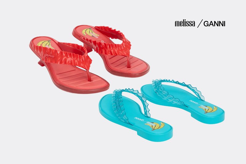 Rote und türkise Rüschen-Flip-Flops mit niedrigen Absätzen, Bananenmotiv auf den Innensohlen, gekennzeichnet als Melissa und Ganni Zusammenarbeit.