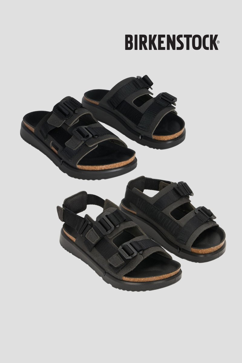 Deux paires de sandales Birkenstock noires avec des brides réglables et des semelles en liège sur un fond gris uni.