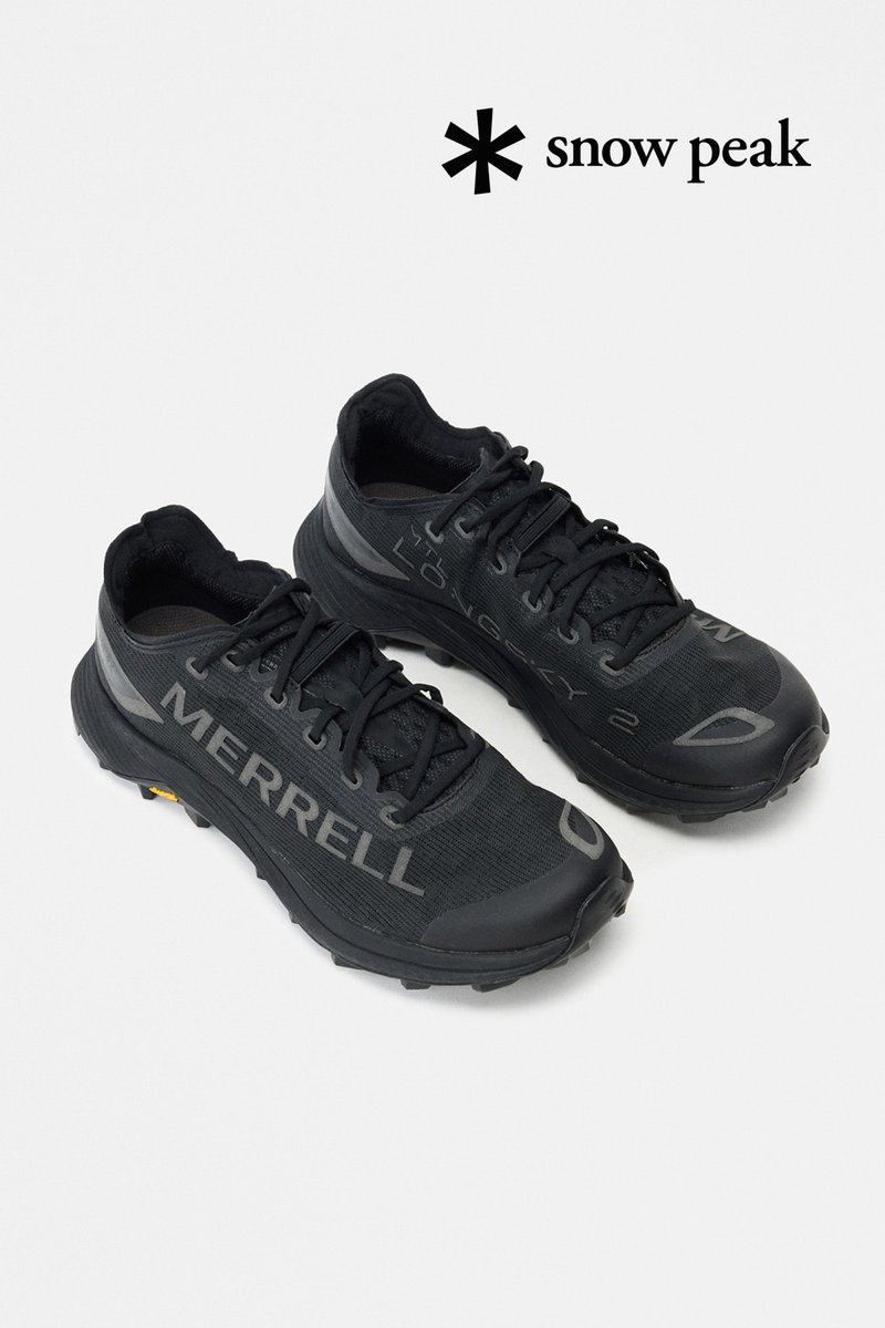 Svarta sportskor med meshöverdel, tydlig "MERRELL"-logotyp, texturerad gummisula och förstärkt tåhätta för hållbarhet.